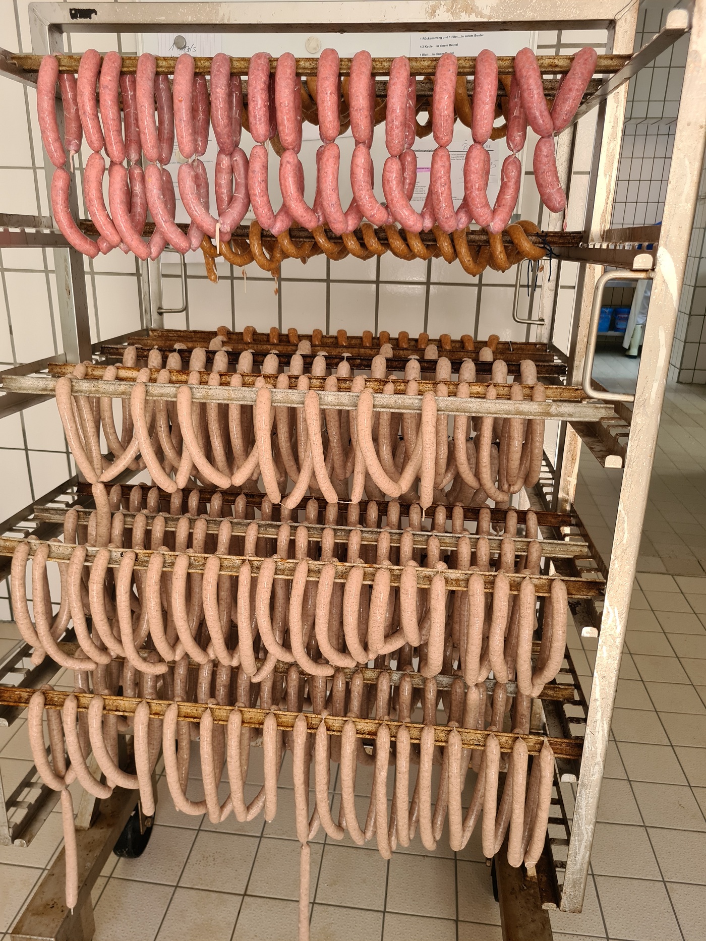 Verschiedene Wurstwaren, die auf einem Regal hängen. Klick führt zu Großansicht.