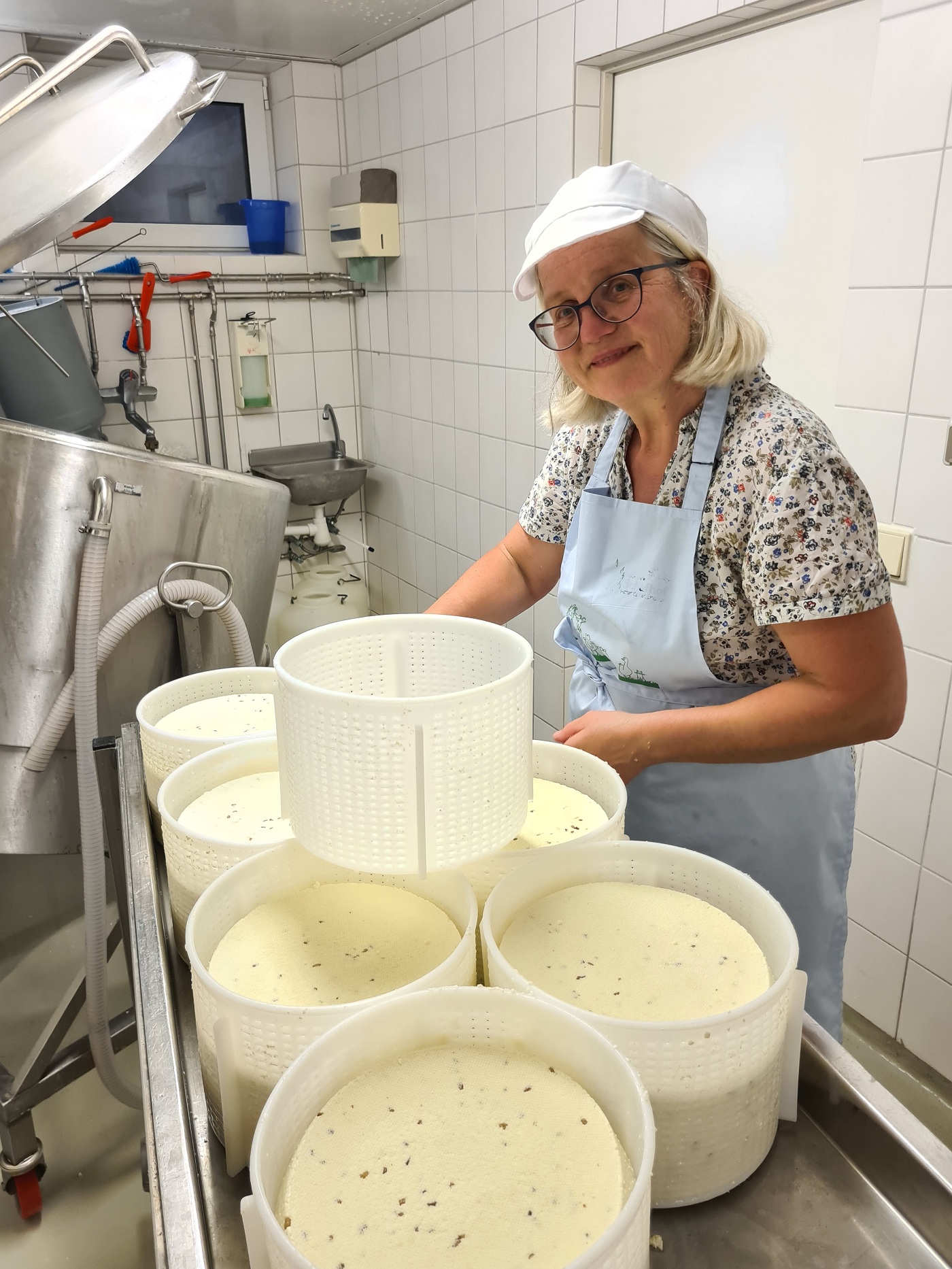 Frau beim Käsemachen. Klick führt zu Großansicht.