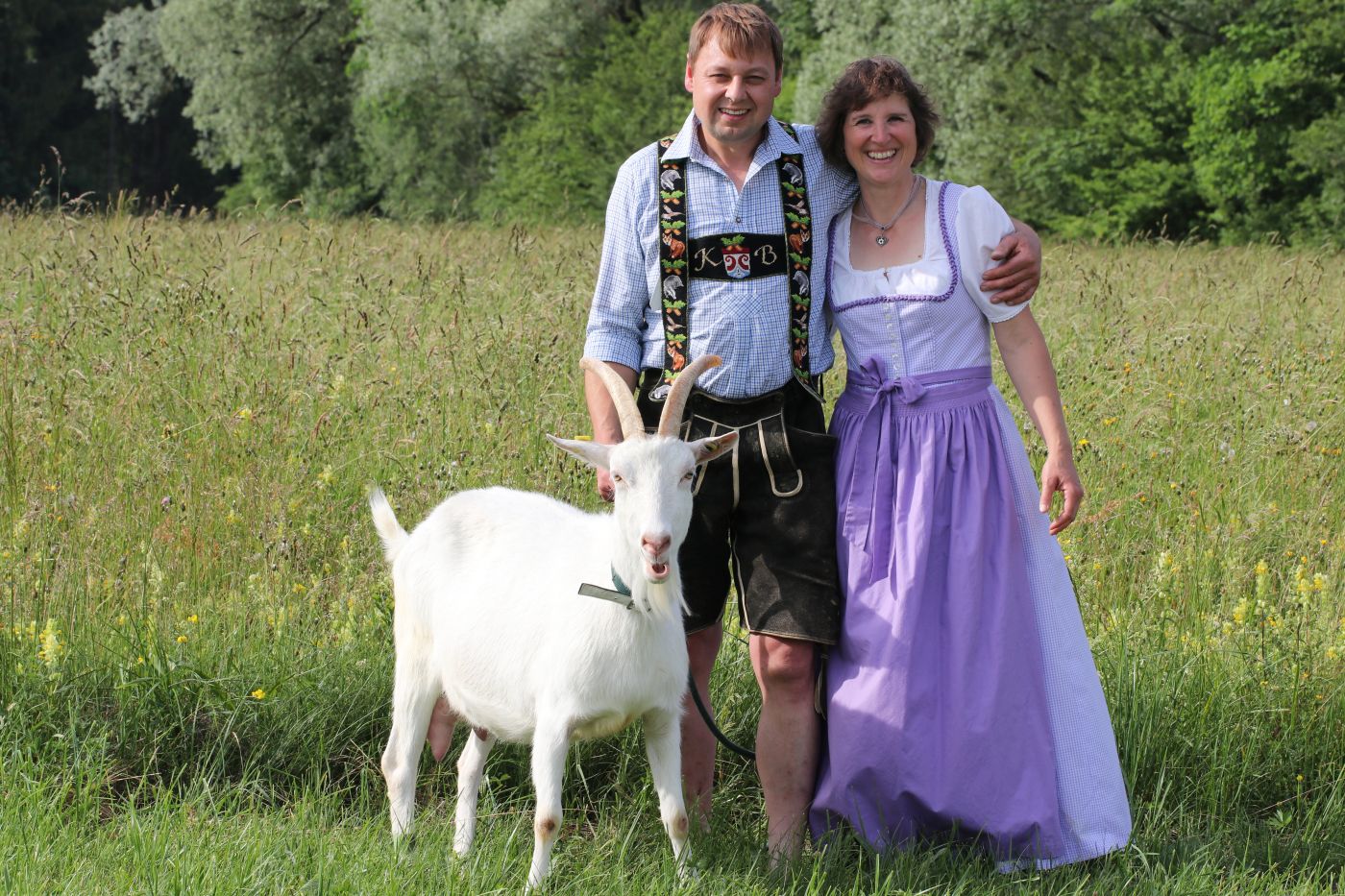 Mann und Frau mit Ziege auf Wiese