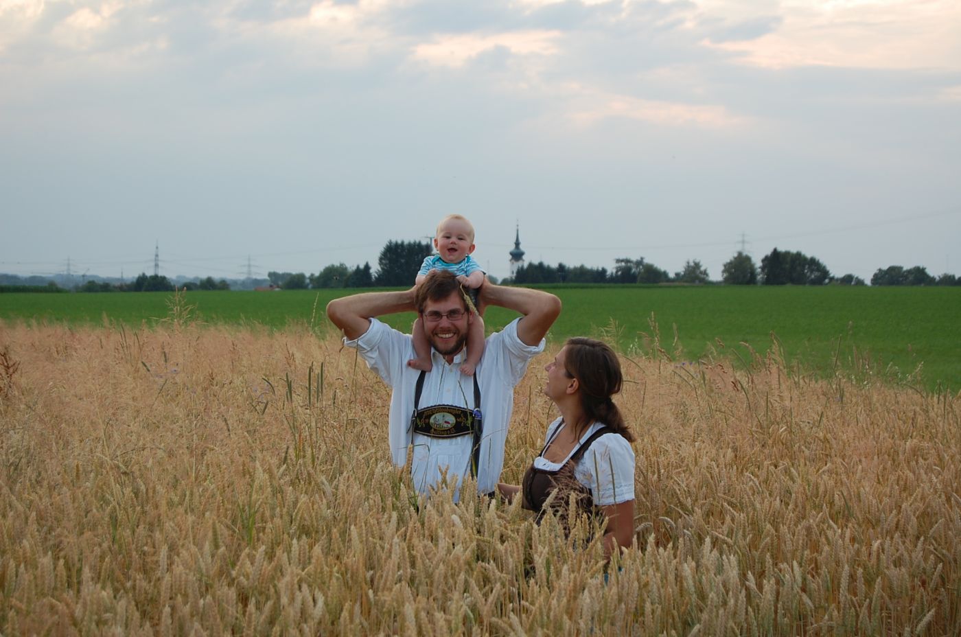 Mann und Frau mit Kind auf Feld